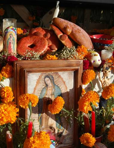 Souls are said to be allowed to visit their families on one day of the year, the Day of the Dead. The candles light their way and represent Christ, while the flowers symbolize the fugacity of life. 