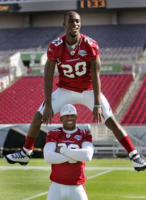 Arizona Cardinals' Dominique Rodgers-Cromartie leaps over teammate Ralph Brown during Super Bowl XLIII media day at Raymond James Stadium Tuesday Jan. 27, 2009, in Tampa Bay, Fla. 
