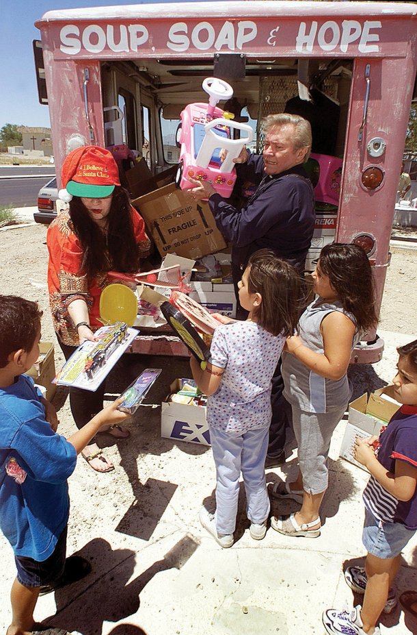 Magickal Marissa and John 3:16 Cook distribute toys to children (2000).
