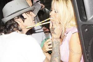 Tommy Lee extends his candy necklace for Pamela Anderson to take a nibble.