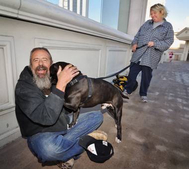 Andy Smith is greeted by Tawnee Roberts and her dog, Concord, on the pedestrian bridge where homeless man 
Larry Minnich was allegedly assaulted (he later died of his injuries). Roberts says she was Minnich’s fiancee.

