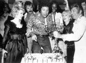 British singer Tom Jones, center, blows out candles at a surprise birthday party at Caesars Palace on June 6, 1974. Guests include Joan Rivers, Sonny Bono, Jones, Dionne Warwick, Debbie Reynolds and Liberace.