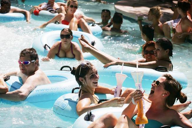 Guests enjoy drinks while floating down the MGM Grand pool's Backlot Lazy River in Las Vegas Monday, July 11, 2011.
