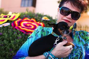 Shannon Paul sits with her dog Miss Mouse, who is sporting a crocheted collar and leash, near the yarn-based public art project installed on the pedestrian bridge across Maryland Parkway north of Desert Inn Road in Las Vegas on Monday, June 11, 2012.