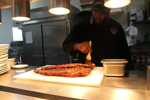 Top Notch Barbeque chef/owner Jimmy Cole puts the final touches on a couple racks of ribs.