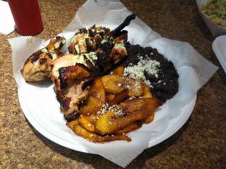 The half chicken platter from Viva Las Arepas, seen here with fried plantains and black beans.
