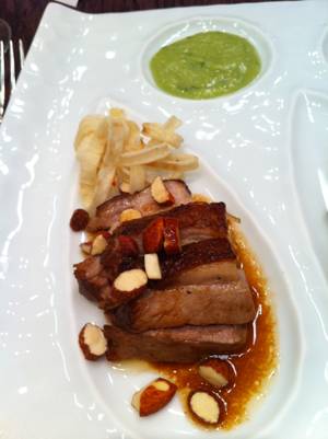 Chef Edmund Wong's braised pork belly with smoked almonds, fried onions and an avocado-jalapeño salsa verde.