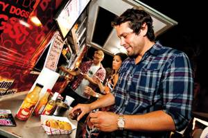Augie, 31, adds some sauce to his specialty hotdog from the Sin City Dog truck at the August 2013 installment of the Vegas StrEATs festival.