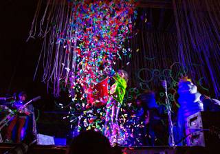 Mark Coyne of The Flaming Lips throws a bucket-full of confetti towards the crowd as they perform on the Ambassador Stage during day 2 of the Life is Beautiful Festival on Friday, October 24, 2014.