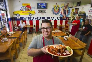 Giovanni Vargas holds a traditional <em>torta ahoggada</em> at El Birotazo Mexican restaurant on East Charleston Boulevard.