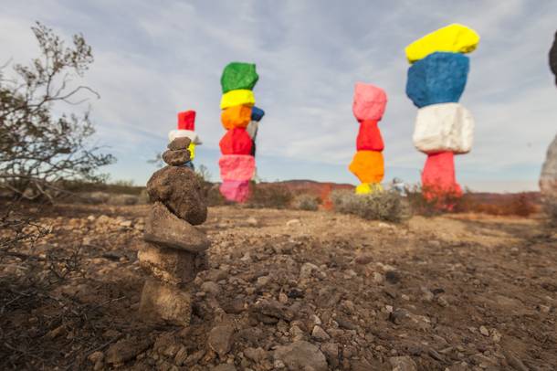 A visitor made a small sculpture in front of Ugo Rondinone’s ‘Seven Magic Mountains’.