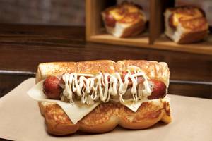 Dog Haus' Scott Bailoi, topped with smoked bacon, white American cheese, garlic aioli and caramelized onions.
