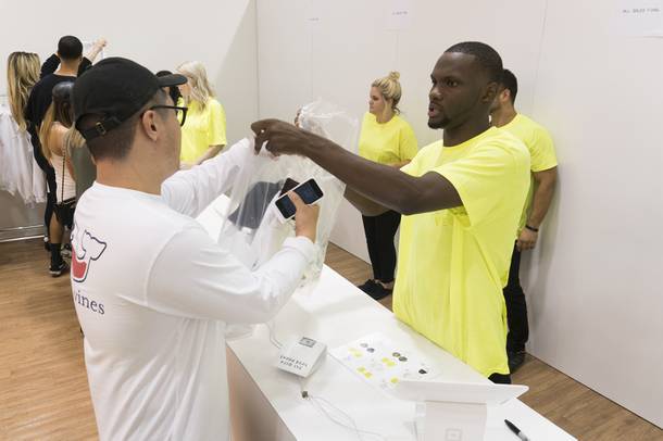 Employee Sean Davis hands a customer his bags after helping him with his purchase at the Kanye West Pablo pop-up shop at Fashion Show Mall, Friday, Aug. 2016.