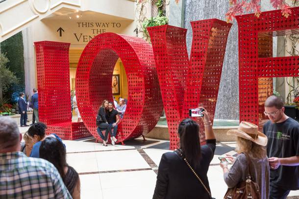 Shoppers take photos with the new 'LOVE' sculpture at Palazzo's Grand Canal Shoppes.