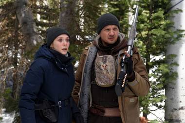 Olsen and Renner track a suspect in the frozen wilderness.
