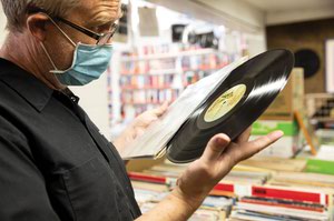 Dave Cleland, who travels around the country looking for vinyl records for his Denver-based record store, Invincible Vinyl, browses through the selection of used records at Record City.