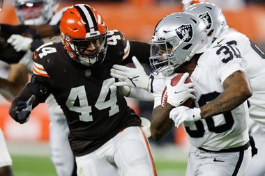 Raiders running back Jalen Richard (30) races past Browns linebacker Sione Takitaki, December. 20 in Cleveland.