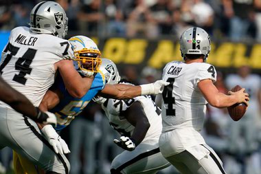 Chargers lineback Khalil Mack reaches for Raiders quarterback Derek Carr on September 11, 2022.