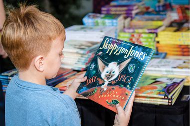 A child looks at a book at the Las Vegas Book Festival