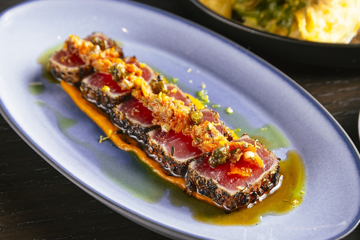 Inside the hidden room, sounds of a bustling dinner service melt away in favor of a cozy bar serving handcrafted cocktails and tapas-style bites.