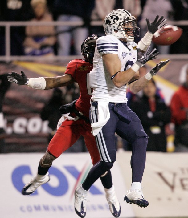 Austin Collie of BYU catches a pass while Devin Ross of the University of Arizona defends during the Las Vegas Bowl at Sam Boyd Stadium Saturday. 

