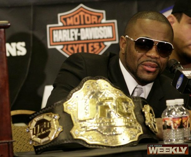 A dapperly dressed Rashad Evans takes questions at the post-fight press conference, next to his Light Heavyweight belt.