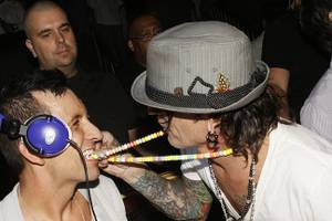 DJ Clinton Sparks takes a bite out of Tommy Lee's candy necklace.