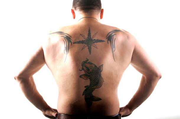 Geno Bernardo shows his tattoo artist father's work on his back.