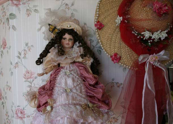 One of the many porcelain dolls lining the walls at Olivia's Dollhouse Tea Room.