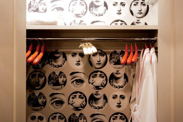Look closely: Fornasetti wallpaper in a guestroom closet.