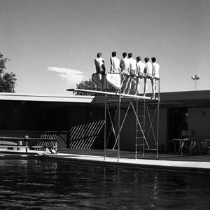 Spectators stand on a diving board to get a better view of a bomb detonation, circa 1953.