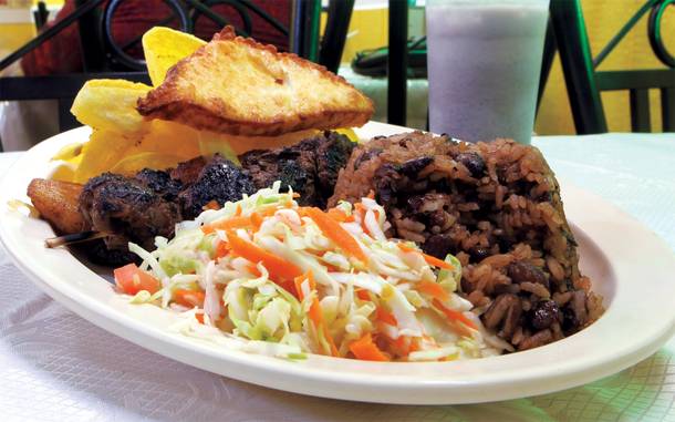 Doña Norma serves its tostones con queso as a side with a skewer of crisp pork and a garlicky rice and bean mixture.