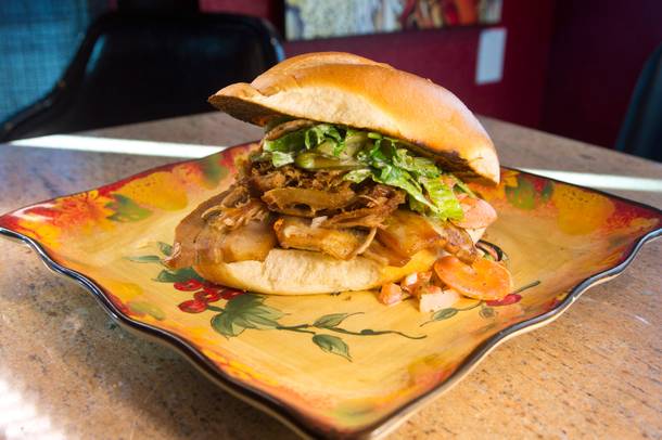 The torta de puerco is loaded with pork belly carnitas, lime-braised pork shoulder, cheese, pickled vegetables and lettuce.
