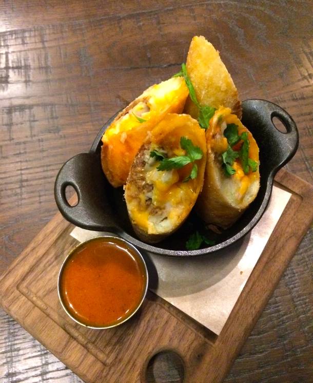 The Crispy BBQ Spring Rolls at Double Barrel Roadhouse are an irresistible appetizer, cheddar mashed potatoes and barbecue beef and pork inside a crunchy wrapper with a tangy mustard-based barbecue sauce on the side.
