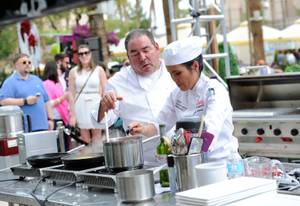 Emeril Lagasse works with culinary student Elsa Sabellano Jenstad for the Chase Sapphire Preferred Grill Challenge during Vegas Uncork'd.