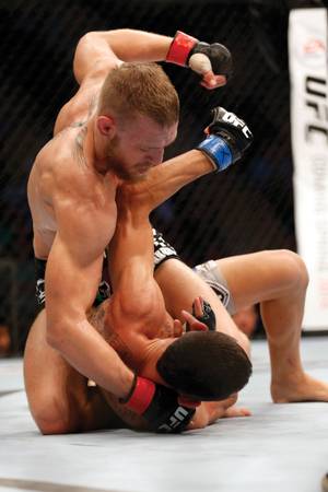 Conor McGregor pounds on Max Holloway in a 2013 bout.