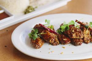 Flock &amp; Fowl's fried chicken wings are finished spicy Szechuan-style or Thai-style with fish sauce, garlic and lemon.