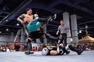 Mondo Deniro and Mondo Rox leg drop onto Dusk during a Versus Pro Wrestling match at the LVL Up Expo. <em>(Wade Vandervort/Staff)</em>
