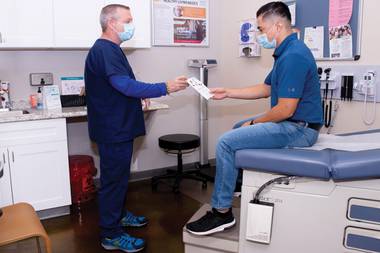 HIV services manager Todd Dickey (left) demonstrates counseling with a client after testing and providing support&nbsp;materials. 