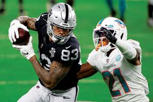 Raiders tight end Darren Waller (83) makes a catch over Dolphins free safety Eric Rowe. 