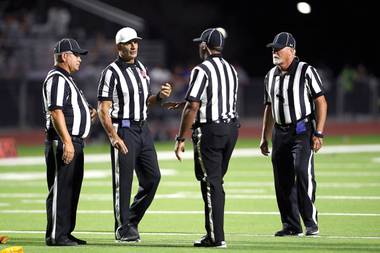 Referees discuss a play with multiple penalties during the Henderson Bowl between Green Valley and Basic at Green Valley High School on September 24. Officials are (from left) Al Eisman, Joe Molinaro, Darwin Murphy and Thomas Donoff.