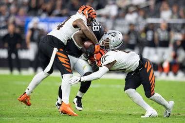 Raiders running back Josh Jacobs (28) gets tackled by Bengals Vonn Bell (24) and Mike Hilton (21) during Las Vegas’ 32-13 loss at Allegiant Stadium on November&nbsp;21.