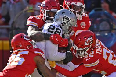 Kansas City’s Juan Thornhill (22) and Charvarius Ward (35) tackle Raiders running back Josh Jacobs December 12 in Kansas&nbsp;City.