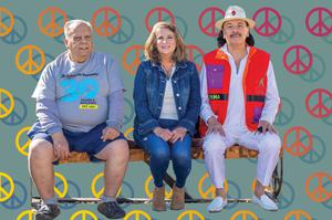 Reuben Nieves, Henderson Mayor Debra March and Carlos Santana sitting on the “PEACE” bench.