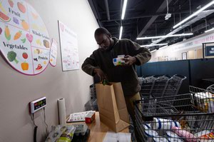 Cashier volunteer Keon Rich packs groceries
