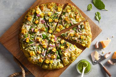 Tandoori chicken pizza comes with white garlic sauce, cheese, bell pepper, red onion, diced tomatoes, cilantro, and juicy, perfectly spiced chicken.
