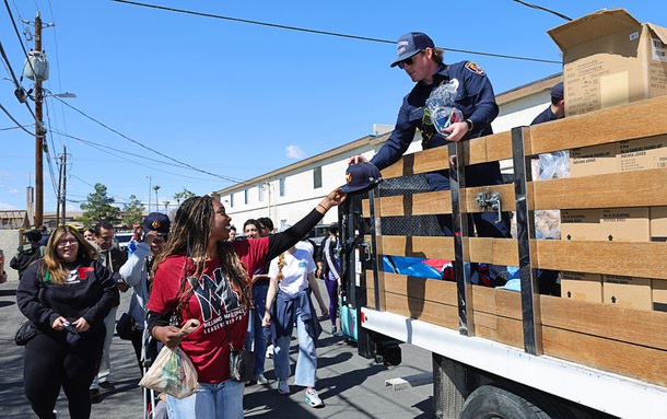 A Clark County Firefighter hands out Las Vegas Aviators hats during the second annual Peace Walk and Super Saturday Family Fun Festival at Cashman Park Saturday, March 15, 2025. The event aims to foster unity, provide resources, and create positive community engagement in the Pennwood/Arville area.