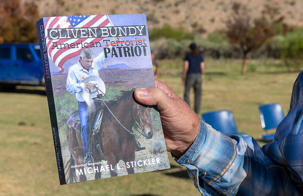Cliven Bundy displays a book written about him during a gathering on the Bundy Ranch in Bunkerville Saturday, April 5, 2025. The gathering was held to commemorate the Bundy standoff against the Bureau of Land Management in 2014.