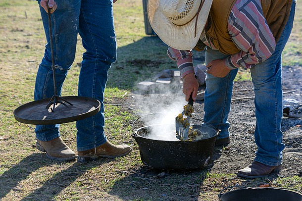 Arden Bundy stirs a Dutch oven of ground beef and potatoes during a gathering on the Bundy Ranch in Bunkerville Saturday, April 5, 2025. The gathering was held to commemorate the Bundy standoff against the Bureau of Land Management in 2014.