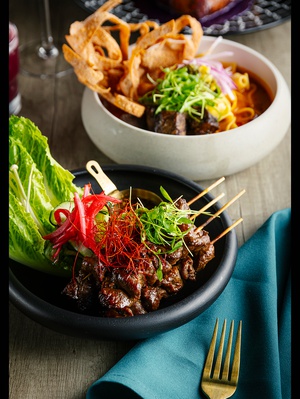 Blue Orchid Thai Kitchen’s Tiger Cry on a Stick (front) and braised short rib Khao Soi.